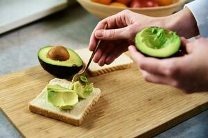 mûr Avocat dans femme mains, en bonne santé petit déjeuner photo