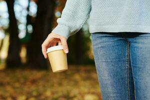 femme tenir tasse de café à emporter dans le l'automne parc photo