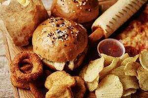 mauvais pour la santé et déchet aliments. différent les types de Fast food et collations sur le tableau, fermer. à emporter nourriture photo