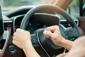 femme conductrice klaxonnant une voiture pendant la conduite sur la route, main contrôlant le volant dans le véhicule. concepts de voyage, de voyage et de transport de sécurité photo