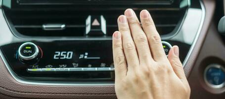 main de femme vérifiant l'air circulant pendant la conduite de la voiture sur la route, système de refroidissement du climatiseur à l'intérieur de la voiture. concept de réglage, de température et de transport photo
