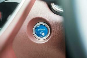 doigt appuyez sur un bouton d'allumage de voiture ou démarrez le moteur à l'intérieur d'une automobile électrique moderne. sans clé, changement, stratégie, vision, innovation et futur concept photo