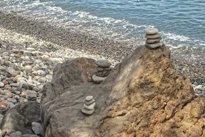 intéressant la tour fabriqué de des pierres arrangé sur le rive de le océan sur une chaud l'été journée photo