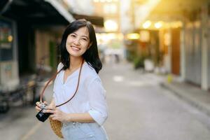 portrait de asiatique femme voyageur en utilisant caméra à rue de Bangkok, Thaïlande. Asie été tourisme vacances concept photo