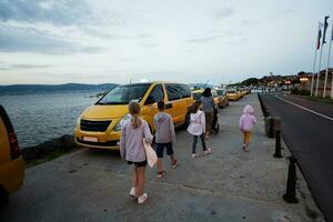 touristes mère avec des gamins attendre pour une Taxi dans nessebar, Bulgarie. photo