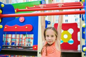 content fille pendaison sur horizontal bar. photo