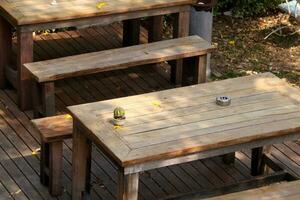 rétro style bois table et longue banc sur bois sol cactus et cendrier sur tableau. photo