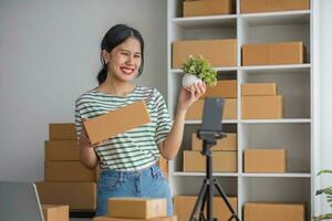 démarrage d'un petit entrepreneur PME indépendant, portrait d'une jeune femme travaillant au bureau à domicile, boîte, smartphone, ordinateur portable, en ligne, marketing, emballage, livraison, b2b, PME, concept de commerce électronique. photo