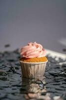 une petit gâteau avec une rose casquette des stands parmi le en volant argent confettis. photo