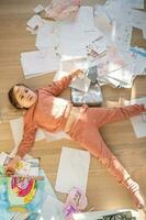 une fille parmi le désordre et épars feuilles dans le chambre. photo