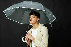 attrayant homme avec transparent parapluie protection de pluie foncé Contexte photo
