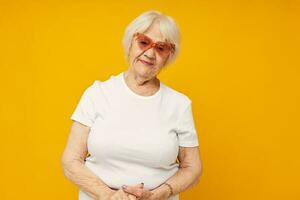 photo de retraité vieux Dame dans une blanc T-shirt porte des lunettes isolé Contexte