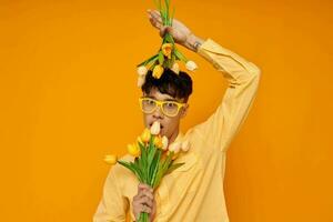 une Jeune homme avec une bouquet de fleurs posant une cadeau isolé Contexte inchangé photo