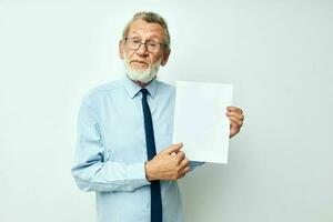 Sénior aux cheveux gris homme dans une chemise avec une attacher copie-espace feuille de papier isolé Contexte photo