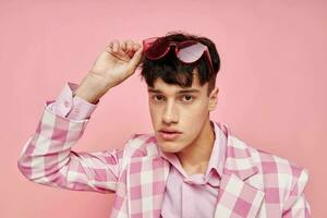 portrait de une Jeune homme rose des lunettes à carreaux veste mode posant modèle studio photo