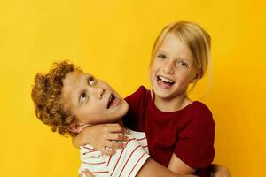 portrait de mignonne les enfants permanent côté par côté posant enfance émotions Jaune Contexte photo