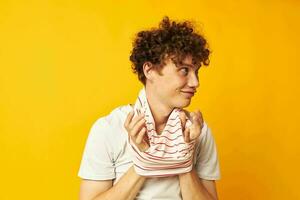 portrait de une Jeune frisé homme en mettant sur une rayé T-shirt posant isolé Contexte inchangé photo