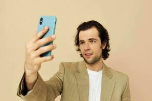 homme avec une téléphone dans main beige costume élégant style isolé Contexte photo