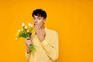 Beau gars dans Jaune des lunettes avec une bouquet de fleurs isolé Contexte inchangé photo