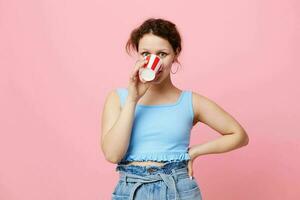 fille en buvant une boisson jetable verre rose Contexte inchangé photo