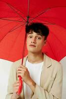 photo Jeune copain en portant un parapluie dans le mains de posant mode lumière Contexte inchangé