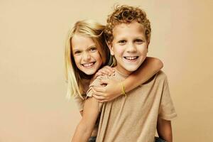 garçon et fille dans beige t-shirts posant pour amusement enfance inchangé photo