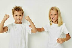 photo de deux les enfants dans blanc t-shirts sont permanent suivant à enfance inchangé