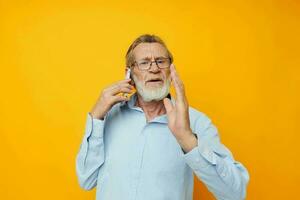 portrait de content Sénior homme gris barbe avec des lunettes parlant sur le téléphone tondu vue photo