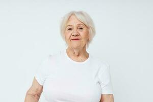 fermer de une de bonne humeur personnes âgées femme dans une blanc T-shirt photo