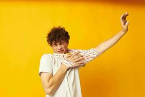 portrait de une Jeune frisé homme rayé t chemise posant été Vêtements isolé Contexte inchangé photo