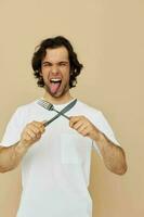 homme dans une blanc T-shirt avec couteau avec fourchette mode de vie inchangé photo