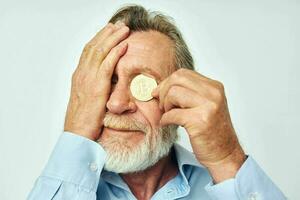 Sénior aux cheveux gris homme dans une bleu chemise bitcoins sur le visage isolé Contexte photo