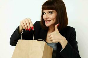 portrait de une femme dans une noir cheveux courts costume papier sac mode de vie inchangé photo