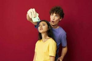 Jeune homme et fille dans coloré t-shirts avec une téléphone jeunesse style photo