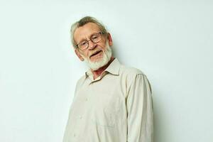 portrait de content Sénior homme avec une gris barbe dans une chemise et des lunettes tondu vue photo
