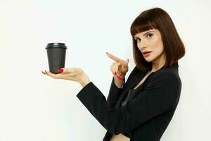 magnifique femme dans une noir costume une agresser avec une boisson charme isolé Contexte photo