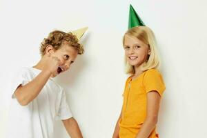 de bonne humeur les enfants posant émotions vacances coloré casquettes isolé Contexte inchangé photo