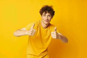 gars avec rouge frisé cheveux Jaune T-shirt mode main gestes isolé Contexte inchangé photo