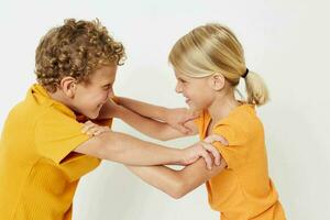 petit les enfants dans Jaune t-shirts permanent côté par côté enfance émotions lumière Contexte inchangé photo