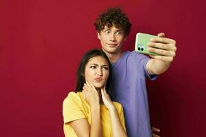 agréable gars et fille dans coloré t-shirts avec une téléphone jeunesse style photo