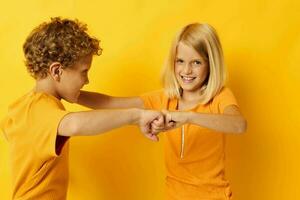 petit les enfants dans Jaune t-shirts permanent côté par côté enfance émotions Jaune Contexte photo