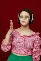 femme dans rose chemisier et vert short écoute à la musique avec écouteurs photo