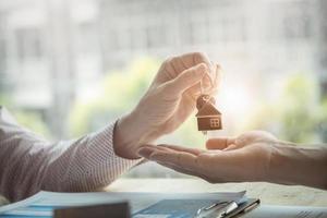 les agents immobiliers acceptent d'acheter une maison et donnent les clés aux clients