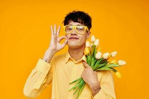 photo de romantique Jeune copain avec une à la mode coiffure dans Jaune chemises avec fleurs Jaune Contexte inchangé