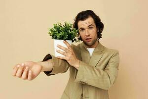 de bonne humeur homme dans une costume posant émotions fleur pot isolé Contexte photo