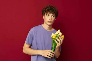 pervers gars en portant une Jaune bouquet de fleurs violet t-shirts isolé Contexte inchangé photo