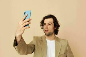 Beau homme prend une selfie classique style les technologies beige Contexte photo