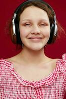 souriant fille dans rose chemise portant écouteurs écoute à la musique fermer photo
