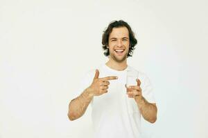 attrayant homme verre de l'eau dans le sien mains émotions posant isolé Contexte photo