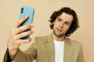 Beau homme avec une téléphone dans main beige costume élégant style mode de vie inchangé photo